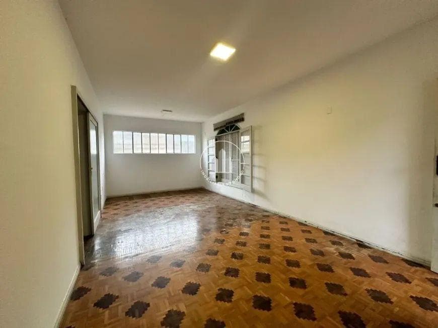 Sala vazia com piso de taco, antes da reforma